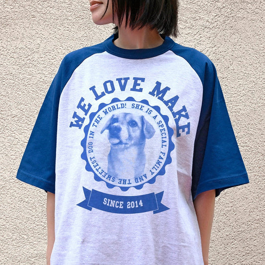 紺と杢グレーのラグランTシャツを着用した様子。胸元に愛犬の顔と「WE LOVE MAKE」のサークル状の英字プリント